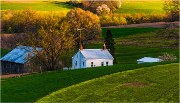 Outside of rural home purchased using a USDA loan surrounded by a field.
